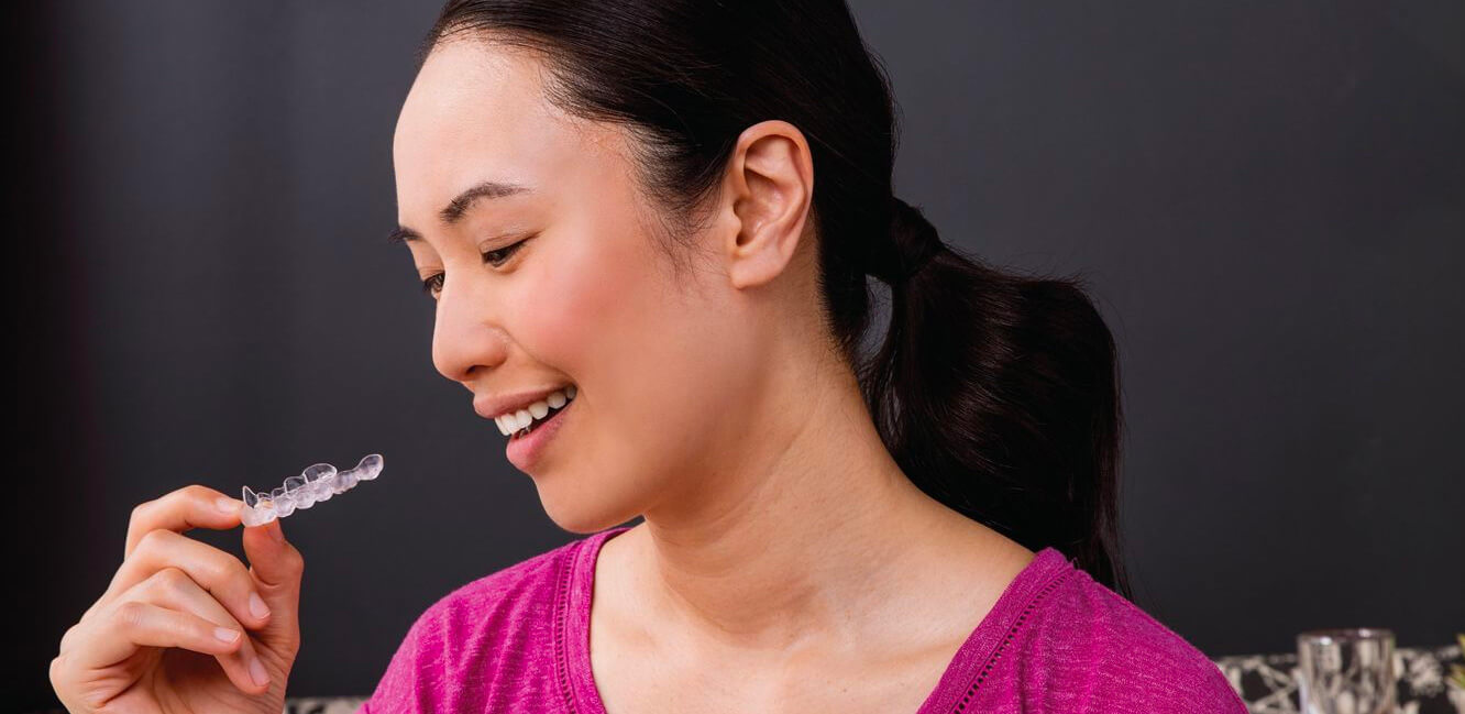 Woman looking at her stained invisalign aligners